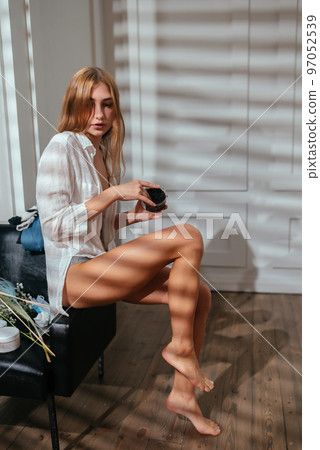 Young woman applying natural scrub on her body at home Young woman applying natural scrub on her body at home 97052539
