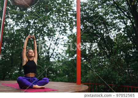 Young woman is practising yoga sitting in the lotus position Young woman is practising yoga sitting in the lotus position 97052565