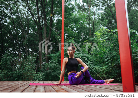 Fitness woman sitting on mat doing yoga 97052581