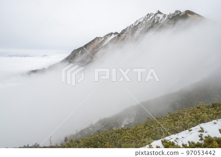 The ridgeline of the Alps seen from the ridgeline of Mt. Nishihotaka on the border of Nagano and Gifu under cloudy skies The mountains of the Northern Alps flowing with clouds The ridgeline of the Alps seen from the ridgeline of Mt. Nishihotaka on the border of Nagano and Gifu under cloudy skies The mountains of the Northern Alps flowing with clouds 97053442