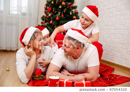 Happy family smiling to camera. Cheerful parents playing with sons Happy family smiling to camera. Cheerful parents playing with sons 97054320