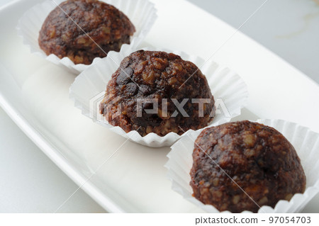 Three chocolate candies sweets on white plate 97054703