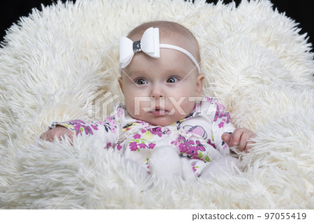 Beautiful baby in a fur blanket. The girl is four months old. Children under one year old. Beautiful baby in a fur blanket. The girl is four months old. Children under one year old. 97055419