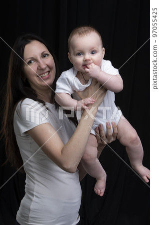 Mom and little son on a dark background. Motherhood. 97055425