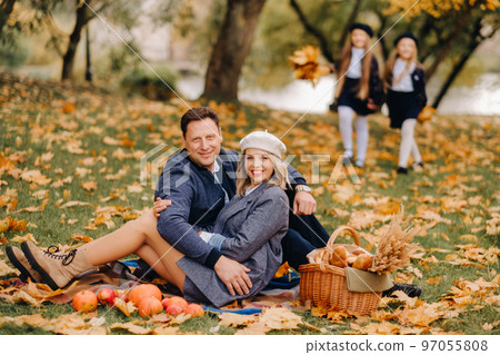 A big family on a picnic in the fall in a nature park. Happy people in the autumn park 97055808