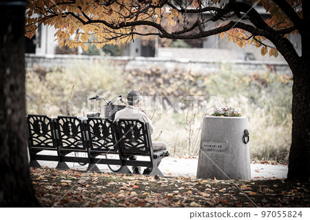 孤獨的老人獨自坐在公園長椅上 97055824