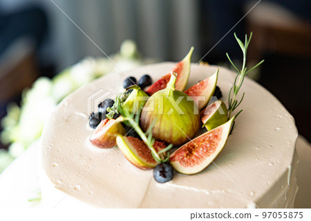 A large cake topped with figs that has a sophisticated atmosphere for adults 97055875