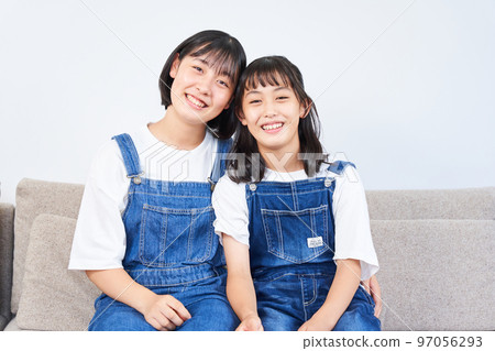 sisters sitting on the sofa sisters sitting on the sofa 97056293