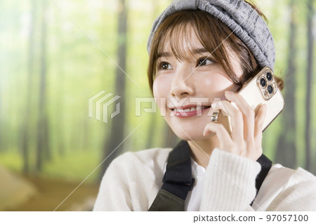 A young woman talking on her smartphone while camping at home Home camping Camping image A young woman talking on her smartphone while camping at home Home camping Camping image 97057100