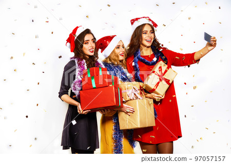 portrait of three happy young women in santa claus hat with gift and sparklers .Christmas concept. 97057157