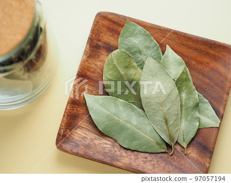 Dried bay leaves on a wooden plate Dried bay leaves on a wooden plate 97057194