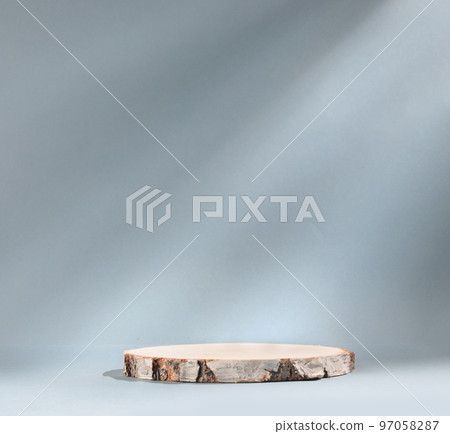 Round wooden slab of cylindrical birch slab on gray background with sunlight Podium. An empty showcase for product presentation 97058287