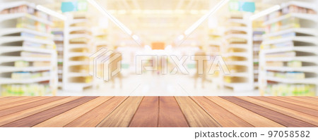 Wood table top with supermarket grocery store aisle interior blurred background with bokeh light for product display Wood table top with supermarket grocery store aisle interior blurred background with bokeh light for product display 97058582