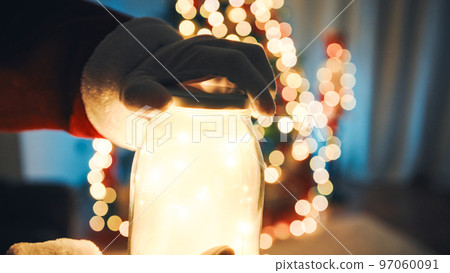 Hand of Santa opening a cup full of Christmas lights 97060091