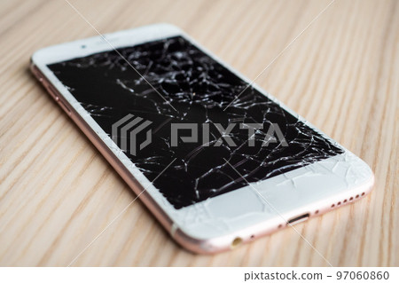 broken glass of mobile phone screen on wooden background 97060860