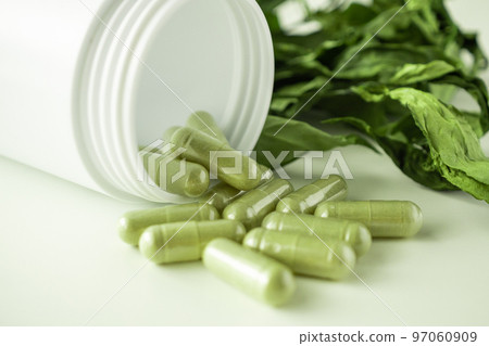 Herbal medicine capsules with Andrographis paniculata leaf on white background Herbal medicine capsules with Andrographis paniculata leaf on white background 97060909