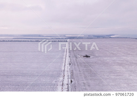 Clear snowy field with pink sunset and the sea in the distance Clear snowy field with pink sunset and the sea in the distance 97061720