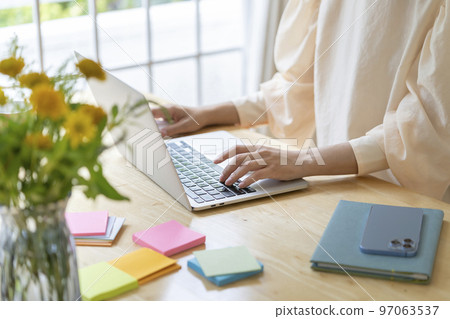 Hands of a young woman working on a laptop 97063537