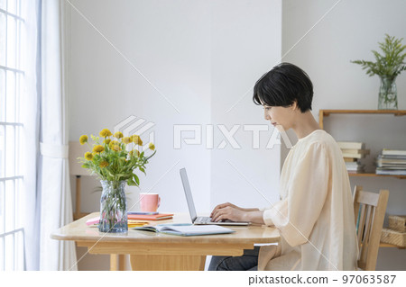 在筆記本電腦上工作的年輕女性 97063587