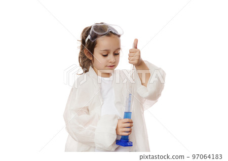 Smart primary school student, little girl in lab coat, filling the glass laboratory graduated pipette with a blue liquid chemical solution from a measuring cylinder. Kids learning chemistry. Education 97064183