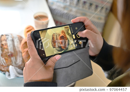 一位女士用她的智能手機 Deli 麵包在露營車裡時尚地拍攝一頓飯 一位女士用她的智能手機 Deli 麵包在露營車裡時尚地拍攝一頓飯 97064457