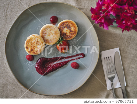 Cottage cheese pancakes or syrniki on a plate 97065731