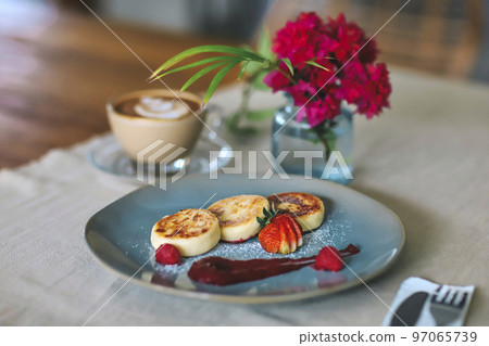 Cottage cheese pancakes or syrniki on a plate 97065739