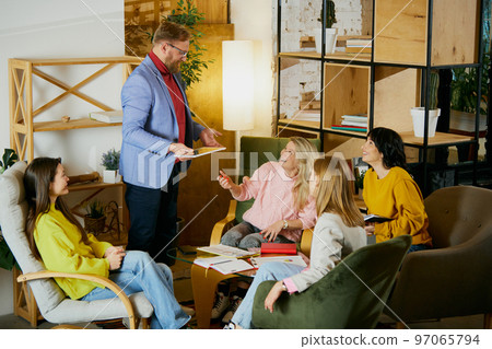 Group of employees, man and women, colleagues having meeting, projects discussion at the office, indoors. Creative innovations. Concept of business, brainstorming, conference Group of employees, man and women, colleagues having meeting, projects discussion at the office, indoors. Creative innovations. Concept of business, brainstorming, conference 97065794