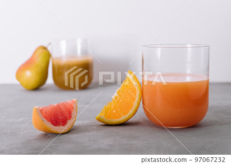 two glasses of orange and pear juice 97067232