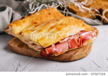 Tasty slices of focaccia bread with prosciutto crudo 97067268