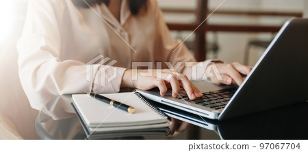 business documents on office table with smart phone and digital tablet and graph financial and woman working at office. 97067704