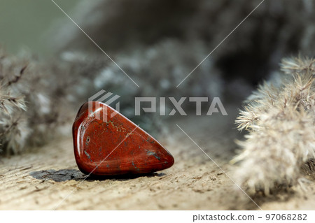 Red Jasper Tumbled Gem Stone on Wood 97068282