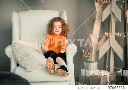 little girl sitting in a cozy chair and showing thumbs up little girl sitting in a cozy chair and showing thumbs up 97068313