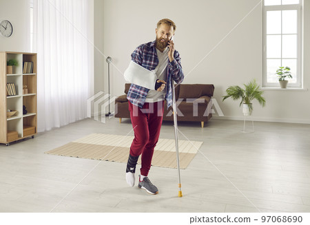 Man with leg and arm injury talks on phone with friends, doctor or insurance company. Man with leg and arm injury talks on phone with friends, doctor or insurance company. 97068690