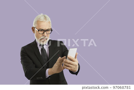 Bad news. Surprised senior man looking at smartphone screen reading shocking message. Posing on purple studio background. 97068781