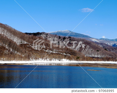 早春的里磐梯，秋元湖。湖面的雪原消失，深藍色的湖水出現，與岸邊的白雪形成鮮明對比。 97068995
