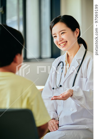 Young female doctor examining an elementary school boy 97069199