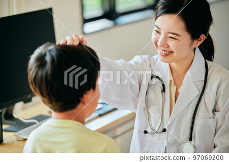 檢查一個小學男孩的年輕女性醫生 97069200