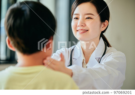 Young female doctor examining an elementary school boy 97069201