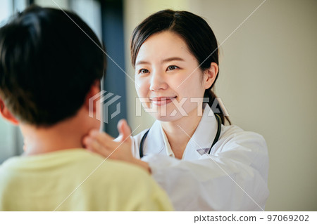 Young female doctor examining an elementary school boy 97069202