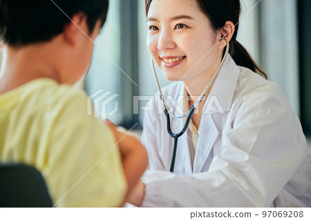Young female doctor examining with a stethoscope on her stomach 97069208
