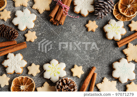 Christmas gingerbread. Delicious gingerbread cookies, cones, dried oranges and cinnamon sticks on grey concrete background. Christmas gingerbread. Delicious gingerbread cookies, cones, dried oranges and cinnamon sticks on grey concrete background. 97071279