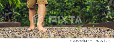 Boy Walking On A Textured Cobble Pavement, Reflexology. Pebble stones on the pavement for foot reflexology BANNER long format Boy Walking On A Textured Cobble Pavement, Reflexology. Pebble stones on the pavement for foot reflexology BANNER long format 97071780