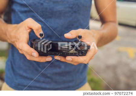 Man holds remote controller with his hands and controls the drone. New technologies and innovations concept 97072274