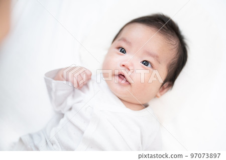 一個2個月大的嬰兒，被爸爸盯著看，回頭微笑 97073897