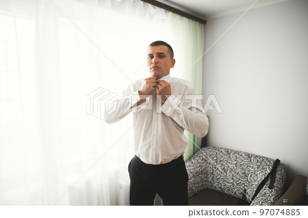 Young handsome man relaxing at his apartment in a hotel after business meeting Young handsome man relaxing at his apartment in a hotel after business meeting 97074885