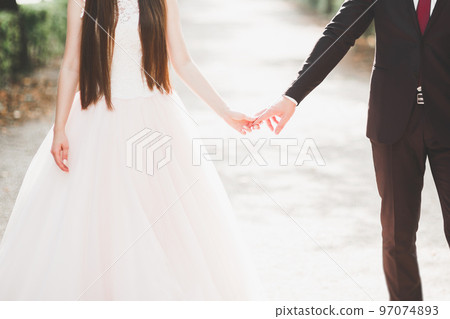 Perfect couple bride, groom posing and kissing in their wedding day Perfect couple bride, groom posing and kissing in their wedding day 97074893