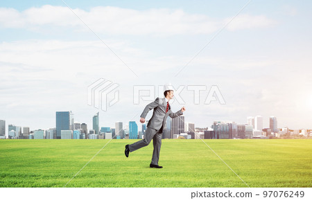 King businessman in elegant suit running on green grass and modern cityscape at background King businessman in elegant suit running on green grass and modern cityscape at background 97076249