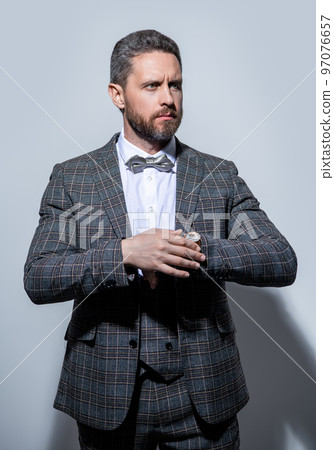 man in tuxedo menswear and wristwatch isolated on grey background. menswear for man in studio man in tuxedo menswear and wristwatch isolated on grey background. menswear for man in studio 97076657