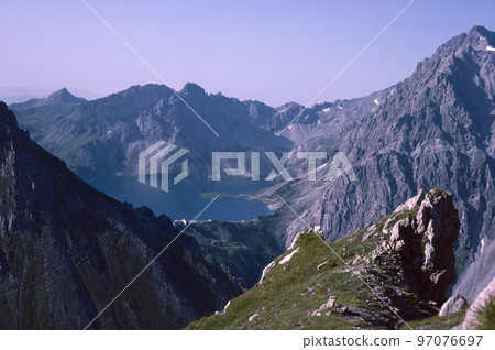 Natural landscape with high mountain peaks of the Rhaetikon in the Eastern Alps at the Luener Lake in Austria 97076697